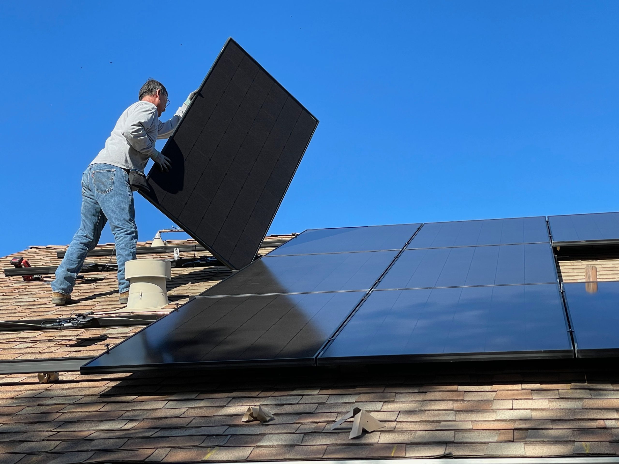 Man sätter upp solcellspaneler på ett tak. Foto Unsplash
